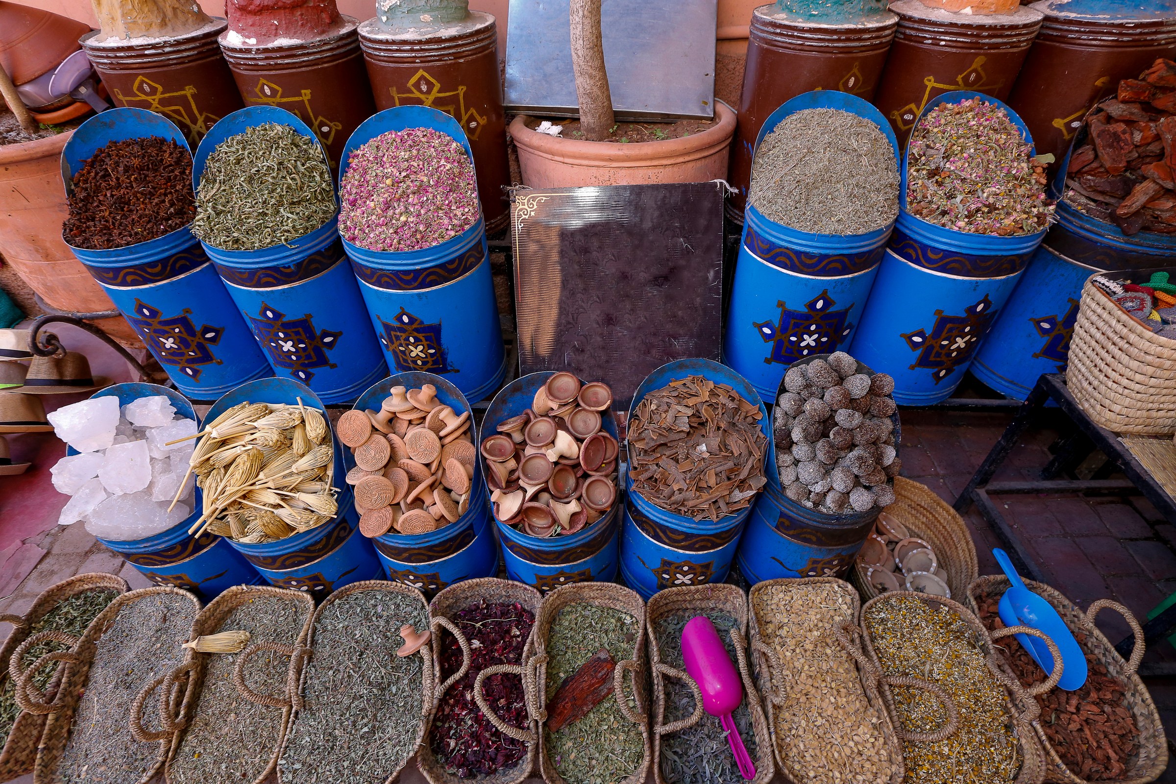 Colourful spices and herbs in blue and gold pots at a Marrakech souk stall