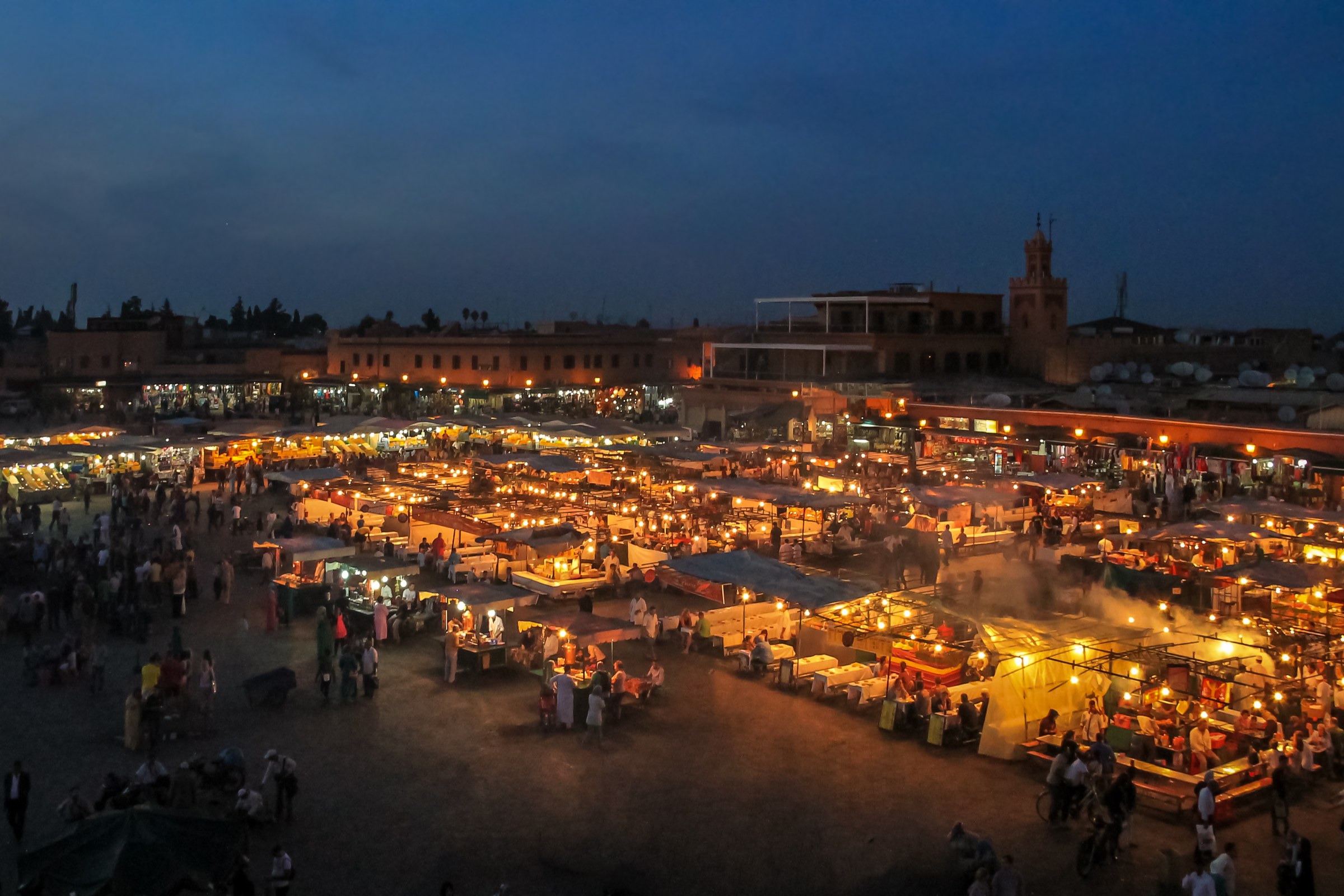 Busy Jemaa el-Fnaa square in Marrakech at dusk, with glowing food stalls and crowds