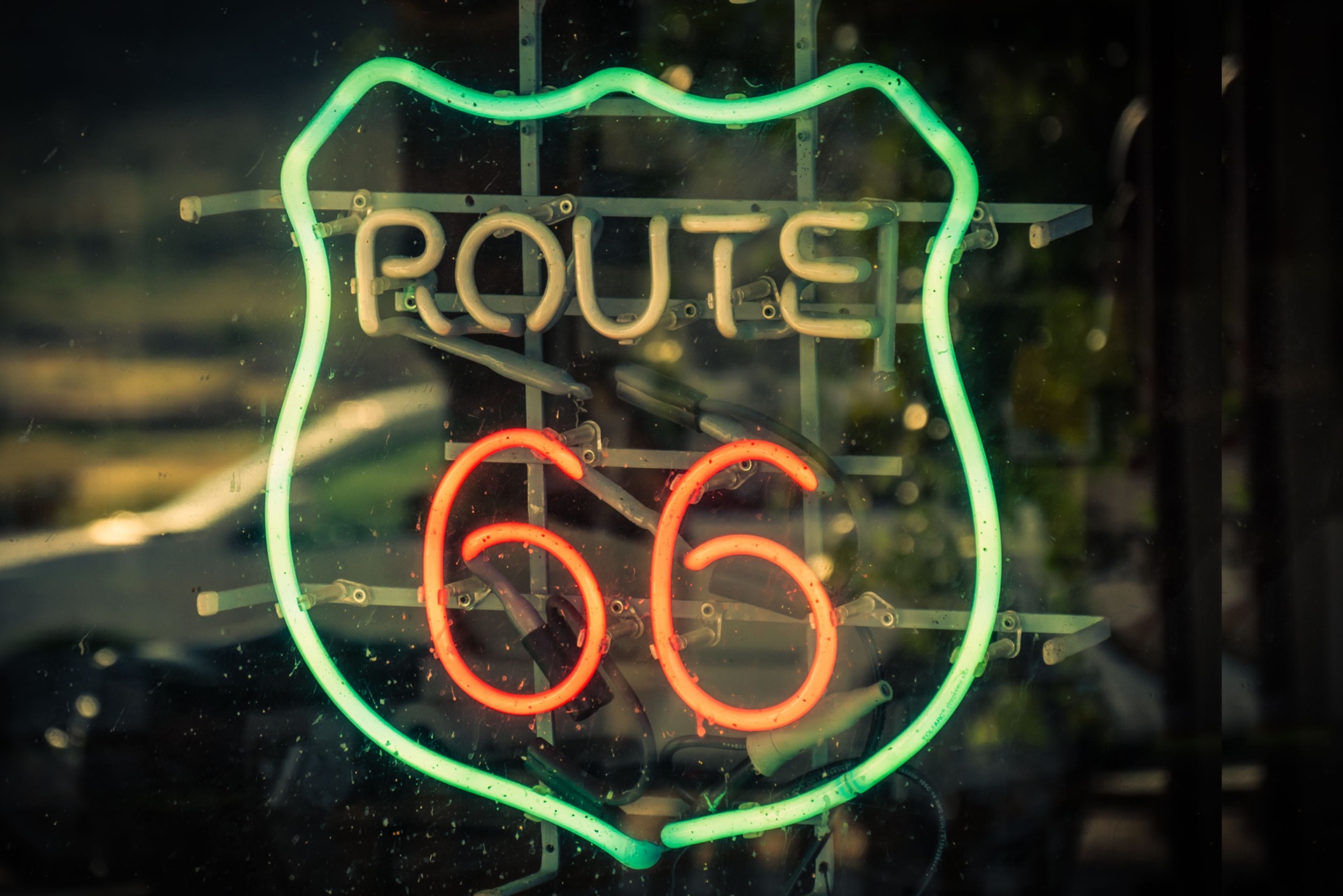 Neon Rote 66 sign with car reflected in the window